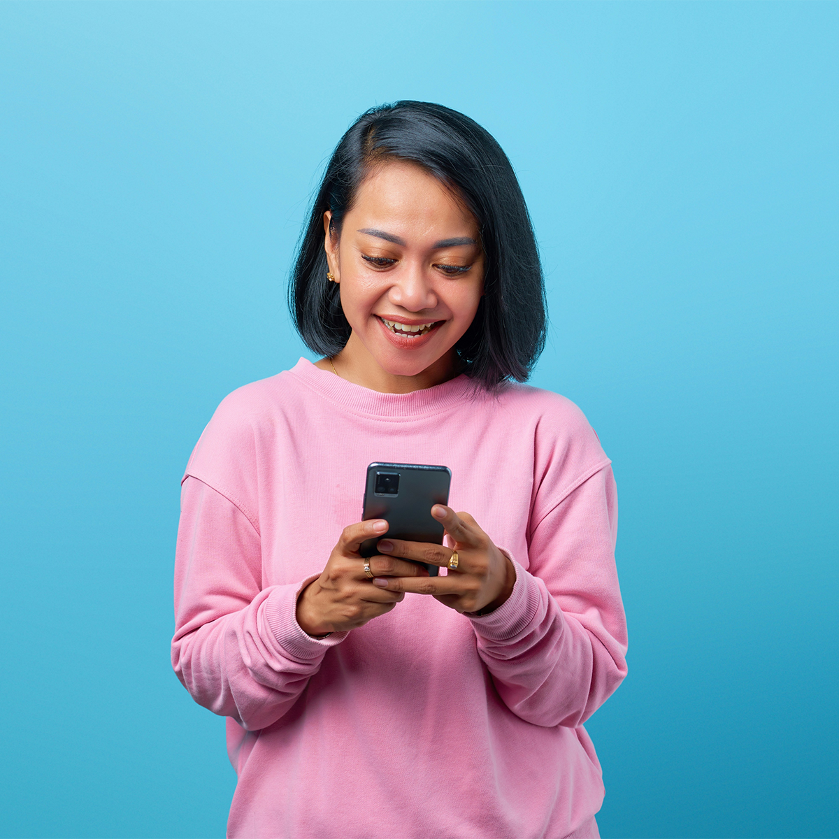 A woman in pink reads her phone