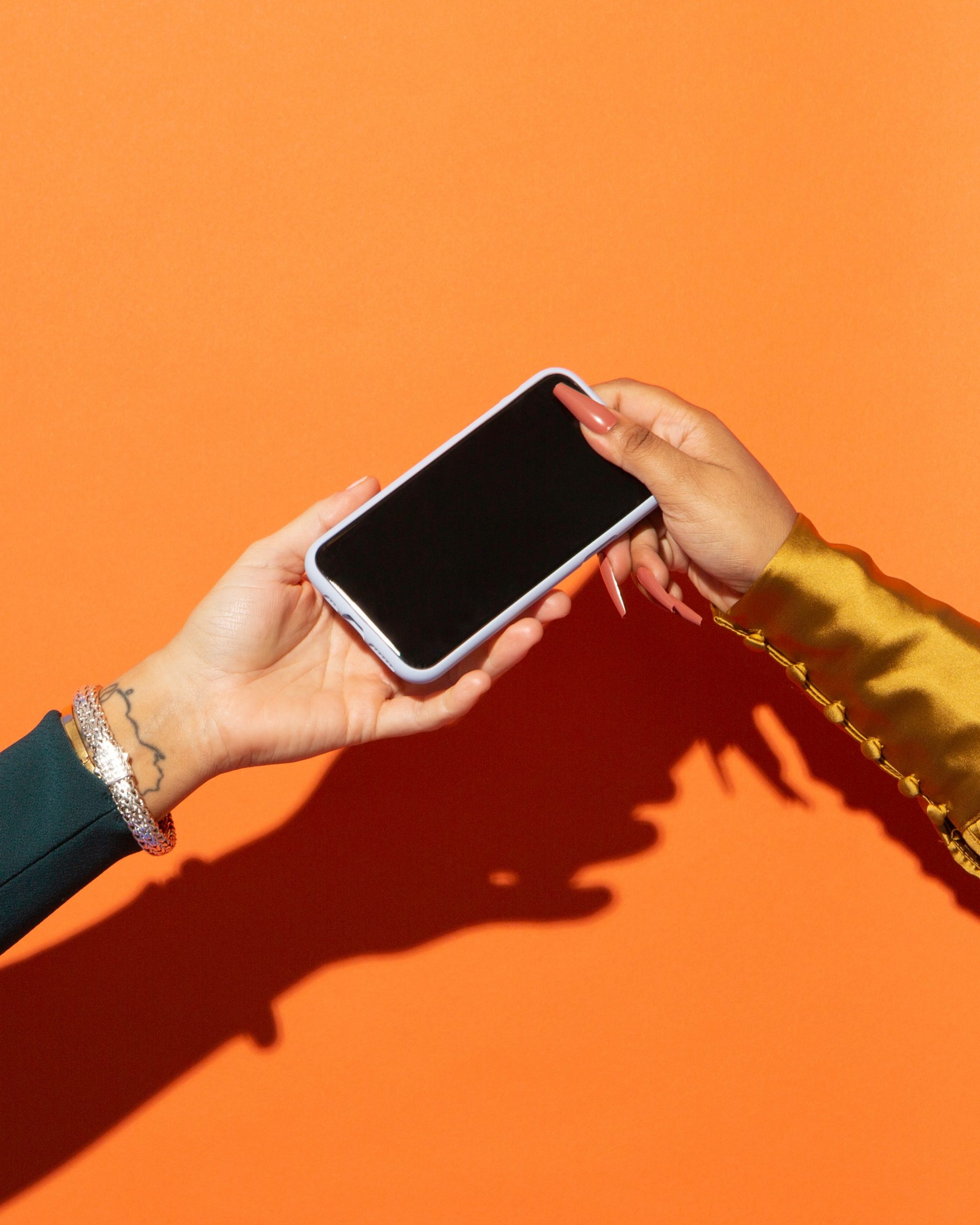 A phone being passed from hand to hand