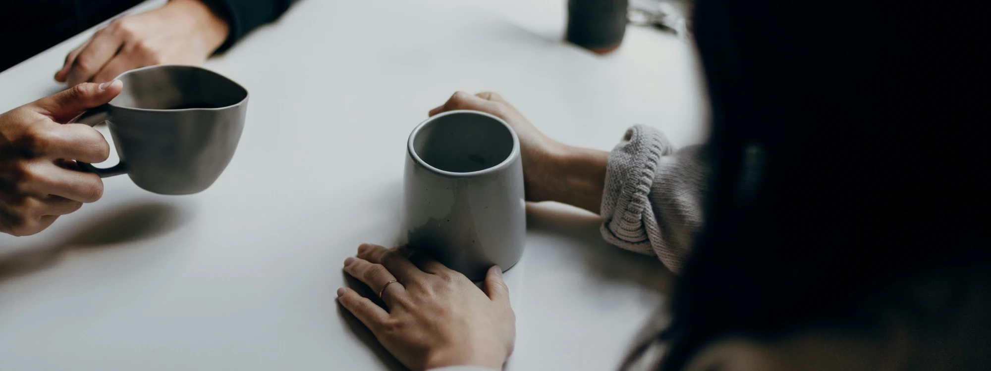 Two People sitting at a table with mugs